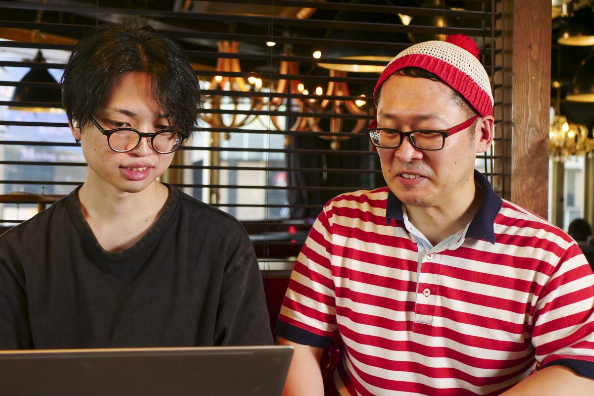 職業指導員の曻さんとワーカーさんが並んで、同じノートパソコンの画面を見ている様子